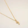 Halsband med hamrat ”9”-hänge i guldmässing Halsband med hamrat ”9”-hänge i guldmässing