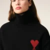 Svart tröja i ull med trattkrage och kontrasterande Ami de Coeur Svart tröja i ull med trattkrage och kontrasterande Ami de Coeur