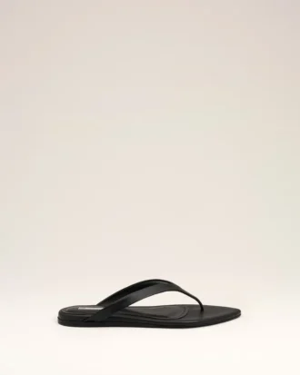 Svarta flip-flops i lammläder med spetsig tå