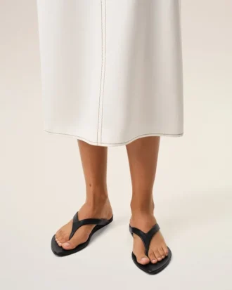 Svarta flip-flops i lammläder med spetsig tå